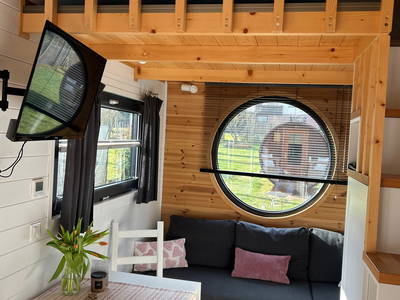 Großes Bullauge mit Blick auf das Saunafass