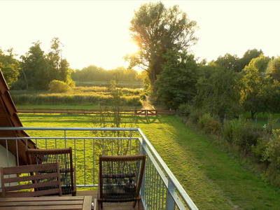 Blick von der Terrasse im Obergeschoss über die Wiese zum See