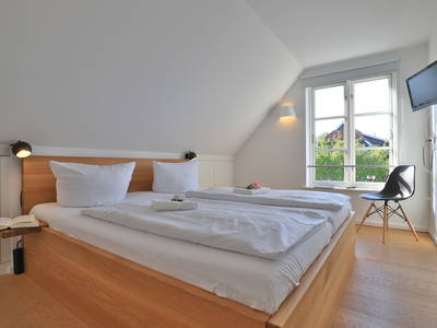 Schlafzimmer mit Doppelbett und TV