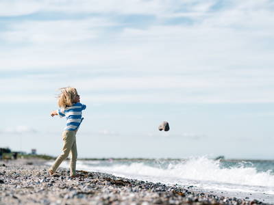 Steine werfen am Strand