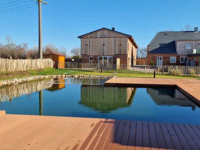 Blick vom Schwimmteich auf die ehemalige Scheune und das Haupthaus