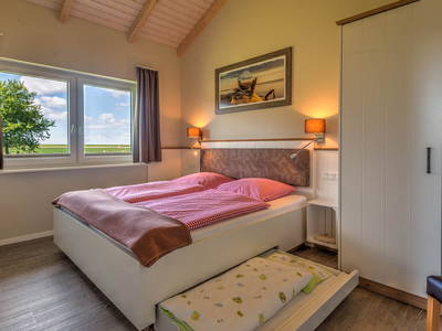 modernes Elternschlafzimmer mit Kinderbett im Wellnesshaus