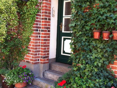 Gästeeingang ins Bauernhaus von der Seite - Scheuneneingang gegenüber. Obwohl die Wohnungen und Häuser alle ein Tiefkühlfach haben, gibt es einen zusätzlichen Gefrierschrank für alle in einem abgeteilten Raum der Scheune.