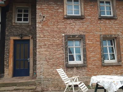 Wohnungseingang mit Blick auf einen Teil der Terrasse und 2 der drei Küchenfenster, darüber zwei der drei Fenster des dritten Zimmers