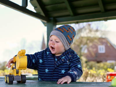 Kind spielt in Sandkiste auf dem Spielplatz