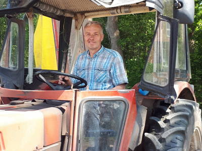 Bauer Hermann mit dem Mähwerk hinter dem Trecker