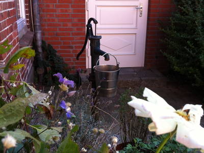 Hinter dieser Tür verbirgt sich der Hauswirtschaftsraum. Davor ist im Innenhof eine Schwengelpumpe, die vor allem die Kinder im Sommer sehr lieben =)